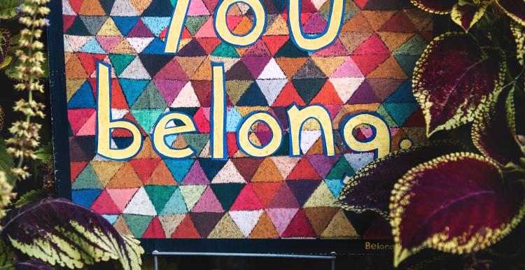 colourful fabric with the words 'you belong' sewn onto it