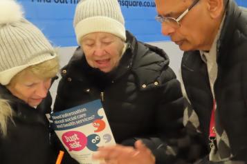 A member of Healthwatch providing an information leaflet to a member of the public in Eldon Square
